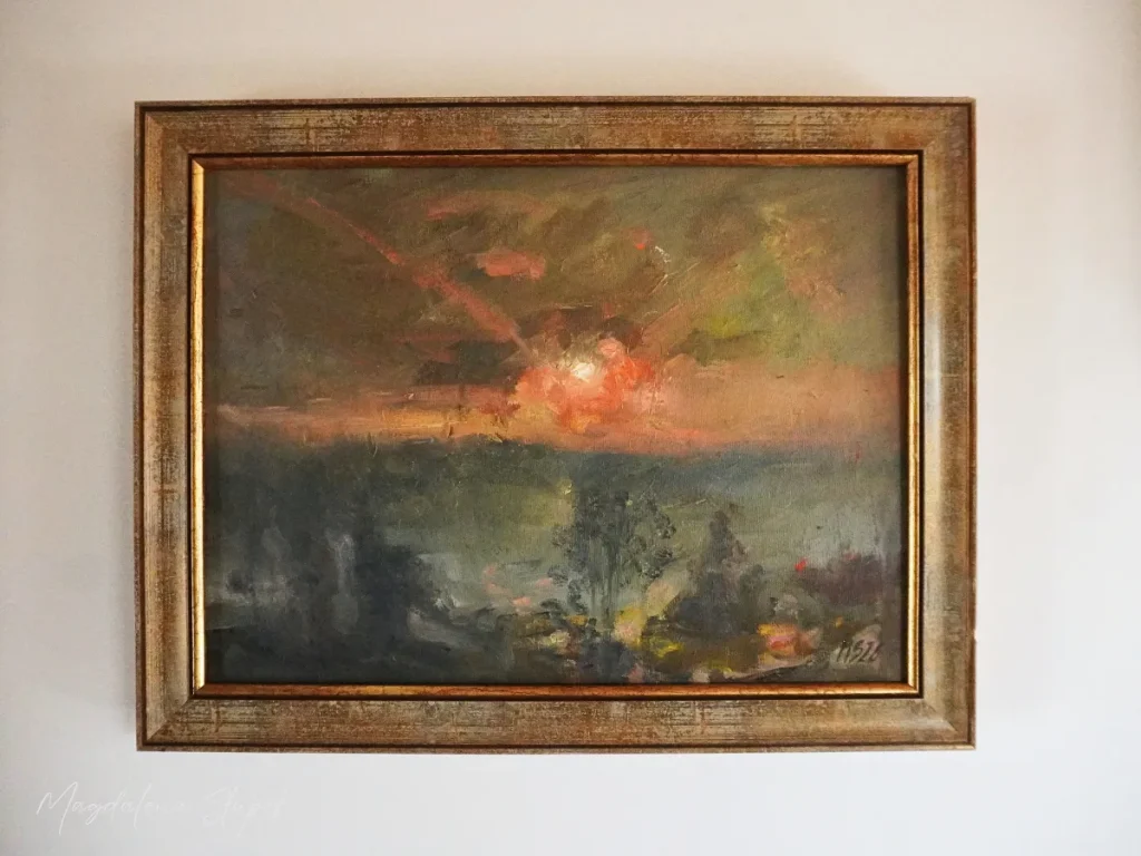 Pejzaż w ciepłych kolorach pomarańczy i zieleni z zachodzącym słońcem